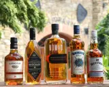 Pięć butelek whisky: Edradour, Antiquary, Nomad, Claymore i Whyte & Mackay. Co to whisky? To trunek z długą historią.