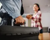 Un plombier arrive avec sa mallette pour régler une fuite d'eau avant compteur. Une cliente le remercie.