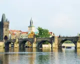 Most Karola w Pradze, z wieżą i zabytkowymi budynkami. To piękne informacje o Czechach.