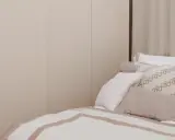 Sovrumsinspiration med en stor, ljus garderob och en inbjudande säng med många kuddar.