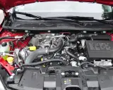 Silnik dCi w czerwonym samochodzie, z widocznymi przewodami, turbosprężarką i innymi elementami.