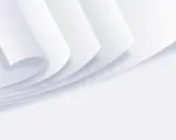 Stos białych kartek papieru zwiniętych w rogu.
