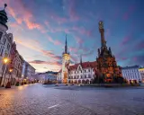 Rynek w Ołomuńcu, perle Moraw Południowych, o zachodzie słońca. Majestatyczna kolumna Trójcy Świętej i ratusz w blasku lamp.