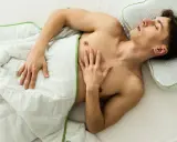 Ein Mann schläft entspannt unter einer Decke, ohne Unterhose schlafen für maximalen Komfort.