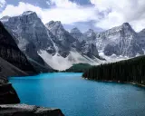 Türkisblaue See vor majestätischen Bergen, ein Traumziel für August-Reisen.