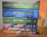 Stos książek z serii Harry Potter części: Kamień filozoficzny, Komnata tajemnic, Więzień Azkabanu, Czara ognia, Zakon Feniksa, Książę Półkrwi i Insygnia Śmierci.