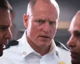 Woody Harrelson i en vit skjorta, omgiven av andra män. En scen från filmer och tv-program med Woody Harrelson.