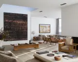 A spacious living room with modern art, including a large abstract piece by tiqui atencio.