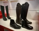 Eleganckie buty do jazdy konnej, znane jako oficerki, prezentowane w różnych stylach i kolorach.