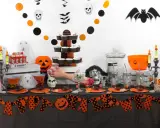 Mesa de **manualidades chuches Halloween** con calabazas, fantasmas, calaveras y dulces.