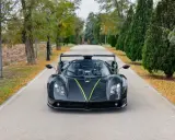 Czarny Pagani Zonda z zielonym akcentem na masce, zaparkowany na alei. Jego cena jest astronomiczna.