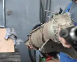Mechanik trzyma zużyty filtr DPF, przygotowując go do czyszczenia.