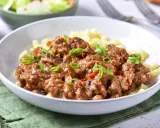 Pyszny strogonow z wieprzowiny z pieczarkami i ogórkiem kiszonym, podany z makaronem. Idealny przepis na obiad.