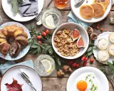 Leckere Brunch-Idee: Marmorkuchen, Müsli, Pancakes, Obst und ein Spiegelei auf rustikalem Holztisch.