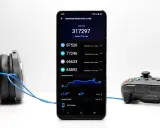 Smartfon Vivo Y72 5G z wynikami benchmarku, słuchawki i kontroler do gier.