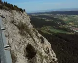 Widok z **Hohe Wand** na dolinę z lasami i wioskami. Stroma, skalista ściana po lewej stronie.
