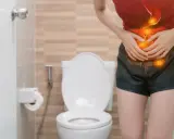 Mujer con dolor abdominal, con ilustración del sistema digestivo en rojo y naranja, frente a un inodoro.