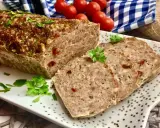 Pyszna pieczeń rzymska na kanapki, pokrojona w plastry, ozdobiona natką pietruszki. Idealna na śniadanie lub kolację.