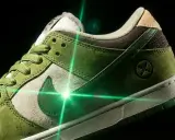 Zielone buty Nike SB Dunk z oryginalną metką, oświetlone zielonym laserem.