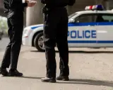 Dwóch policjantów stoi obok radiowozu.