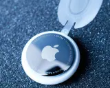 Biały AirTag z logo Apple, pokazujący, jak działa AirTag. Urządzenie z technologią Ultra Wideband.