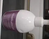 Biała butelka z pompką, na której widnieje napis "nivelium med krem dermatologiczny emolient". Idealny dla skóry z AZS i łuszczycą.