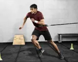Mann trainiert mit Widerstandsband für explosive Kraft. Sein Lunge Sport ist intensiv.