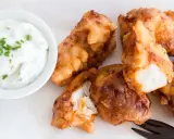 Knusprig frittierte Fischstücke, perfekt für ein Kibbeling Rezept, mit einem cremigen Dip mit Schnittlauch.