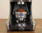 Nahaufnahme des Siebträgers mit frisch gemahlenem Kaffee, bereit zur Einstellung des Sage Smart Grinder Pro.