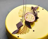 Żółta polewa lustrzana na torcie, ozdobiona marakują, mango, suszonym ananasem i czekoladą. Idealny przepis na polewę lustrzaną.