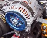 Alternador con polea azul brillante. El cinturón desgastado podría ser la causa del ruido de la polea del alternador.