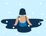 En person i blå baddräkt njuter av isbad i ett kallt, snöigt landskap.