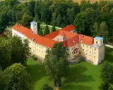 Malowniczy hotel zamek otoczony zielenią.