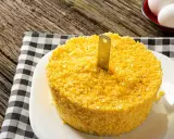Un pastel de maíz amarillo con un cuchillo insertado, listo para servir. Una guía visual para como hacer cous cous.