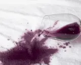 Rozlane czerwone wino na białym materiale. Jak szybko sprać czerwone wino, by ratować ulubioną tkaninę?