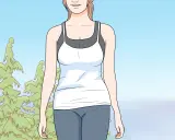 Ragazza sorridente in abbigliamento sportivo, pronta per imparare come correre correttamente tra gli alberi.