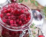 Un bocal rempli de sauce aux canneberges, prête à accompagner votre repas. Des baies rouges brillantes dans une texture gélatineuse.