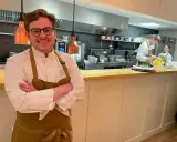 Le chef souriant du restaurant Le Mans, avec son équipe en cuisine.