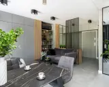 Nowoczesne mieszkanie 30m2 aranżacja: szara sofa, marmurowy stół, dużo zieleni i lustro.