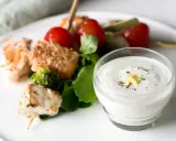 Brochettes de poisson et saumon grillés avec tomates cerises, brocolis et une sauce au yaourt crémeuse.