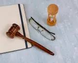 Młotek sędziowski, okulary i klepsydra symbolizują potrzebę przywrócenia terminu do odrzucenia spadku.