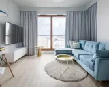 Jasny salon z błękitną kanapą i złotymi dodatkami. Styl włoski inspiracje w nowoczesnym wydaniu.