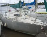 Voilier gris amarré, prêt pour une brise de mer 31. Voiles vertes et bleues, cordages et bouées.