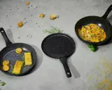 Trzy patelnie nie teflonowe: grillowa z polentą i kukurydzą, okrągła i woka z daniem warzywnym.