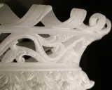 Dettaglio di un vaso in alabastro di Volterra, con decorazioni floreali intagliate e un bordo a onda.