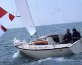 Deux hommes naviguent sur un voilier blanc, le "Esterel", avec des voiles rouges et blanches. Les premiers 22 avis sur ce bateau sont probablement très positifs.