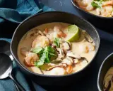 En skål med krämig tom kha gai med räkor, svamp och lime. En smakrik thailändsk soppa.