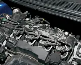 Silnik Volvo V50 1.6 diesel z widocznymi wtryskiwaczami, przewodami i zbiorniczkiem płynu chłodniczego.