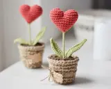 Dos tiernos corazones amigurumi en macetas de yute, uno con una etiqueta que dice "I love you".
