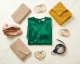 A deep green silk blouse is the centerpiece of this flat lay. What goes with dark green clothes? Think blush pink heels, beige clutches, a mustard yellow scarf, gold bangles, and a navy belt.